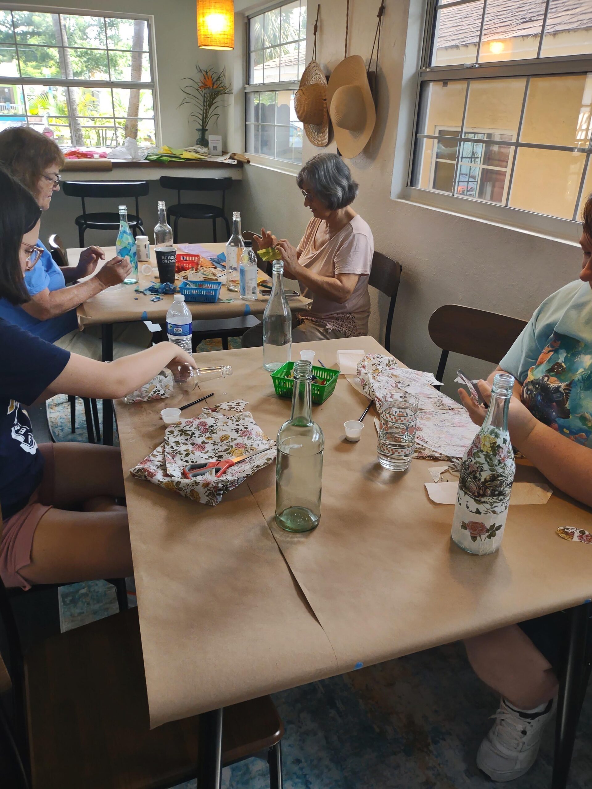 Guests decorating bottles during a craft activity in the cottage
