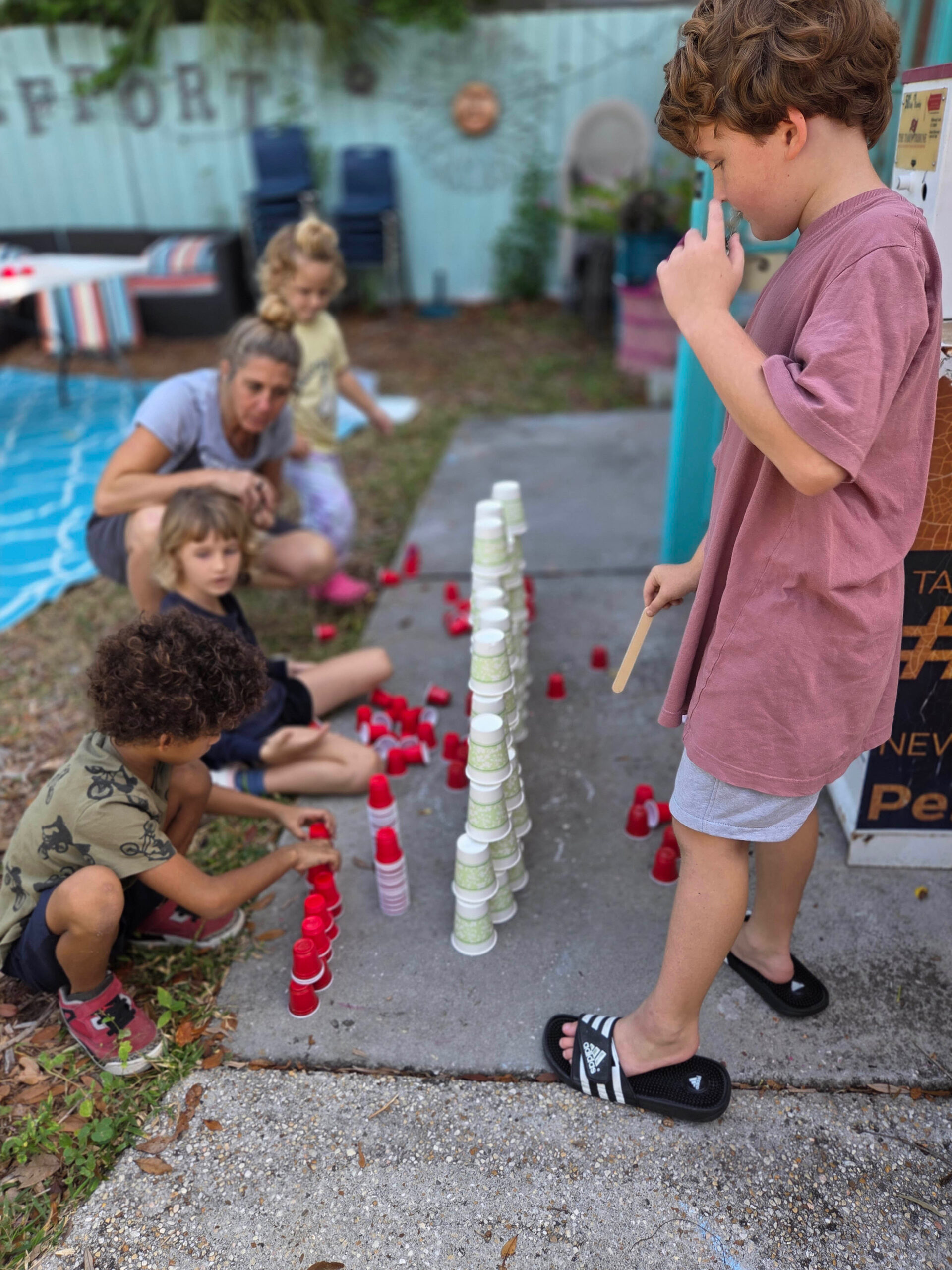 Children stacking cups together during a kids' craft class in the garden