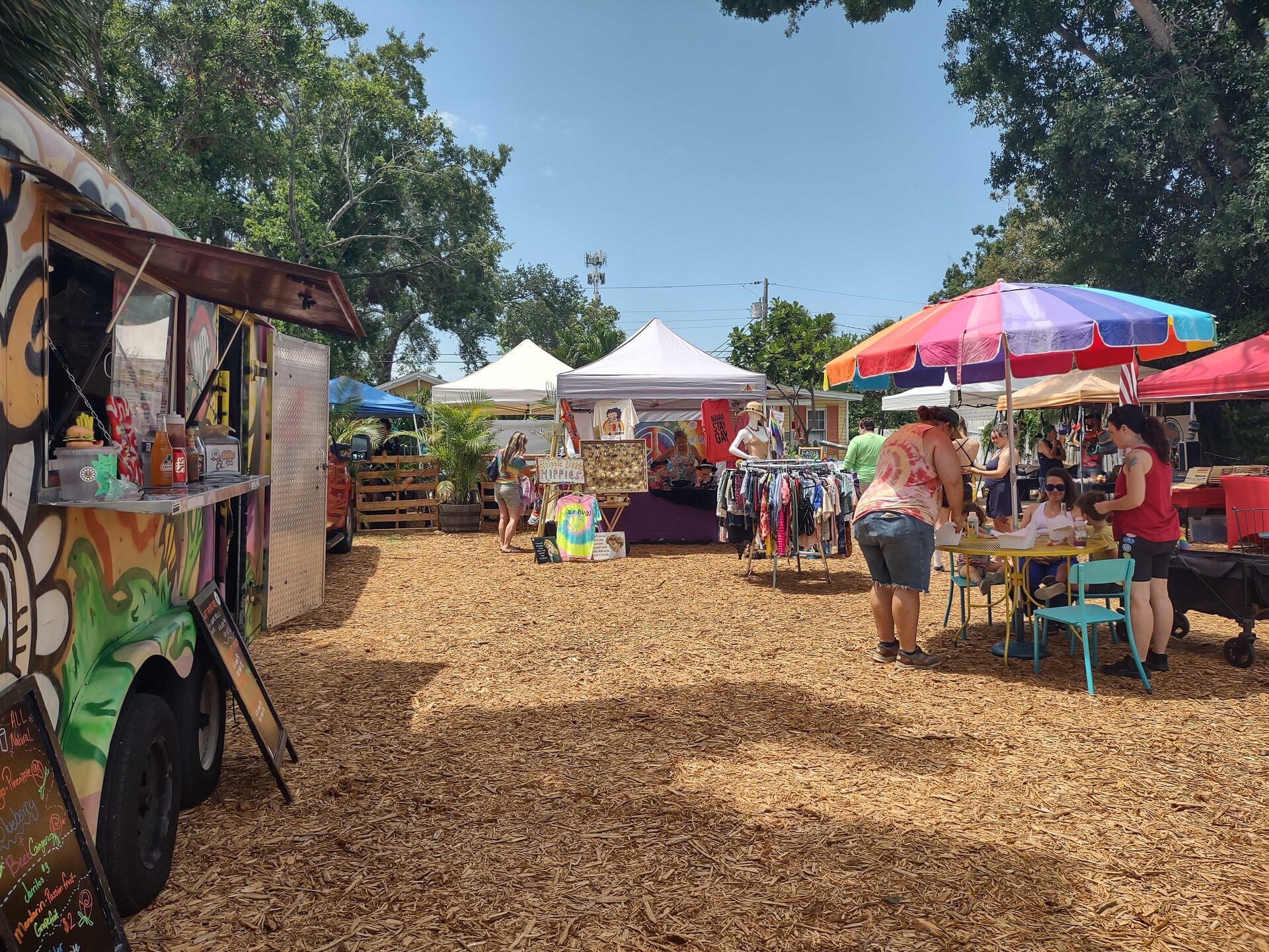 Shoppers browsing vendor tables at a market day event