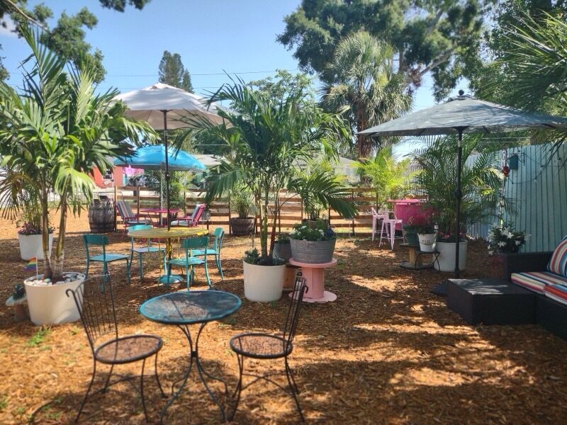 Garden patio with colorful bistro tables and palm trees