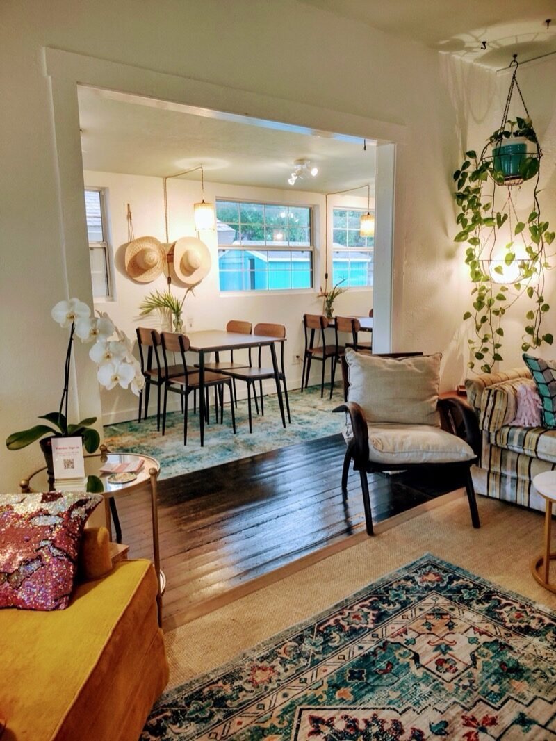 Cozy lounge area with hats hanging on the wall and hanging plants