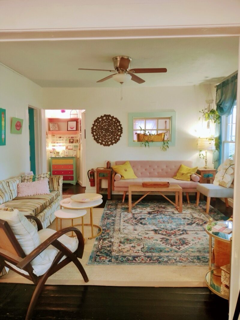Living room with a pink tufted sofa and colorful boho rug